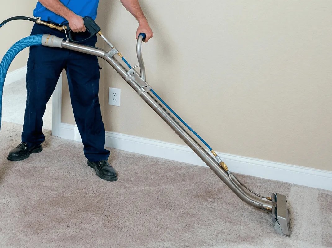 Professional operating a liquid removal machine on a carpeted floor in Bellevue, WA
